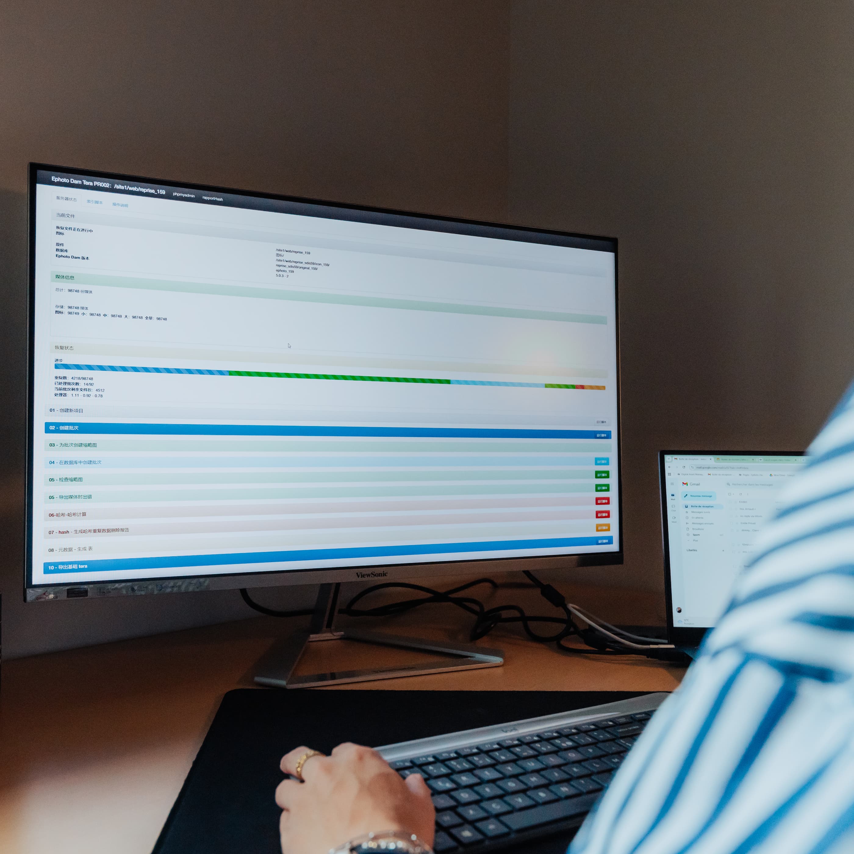 桌子上的电脑,配有键盘、鼠标、台灯和硬盘。