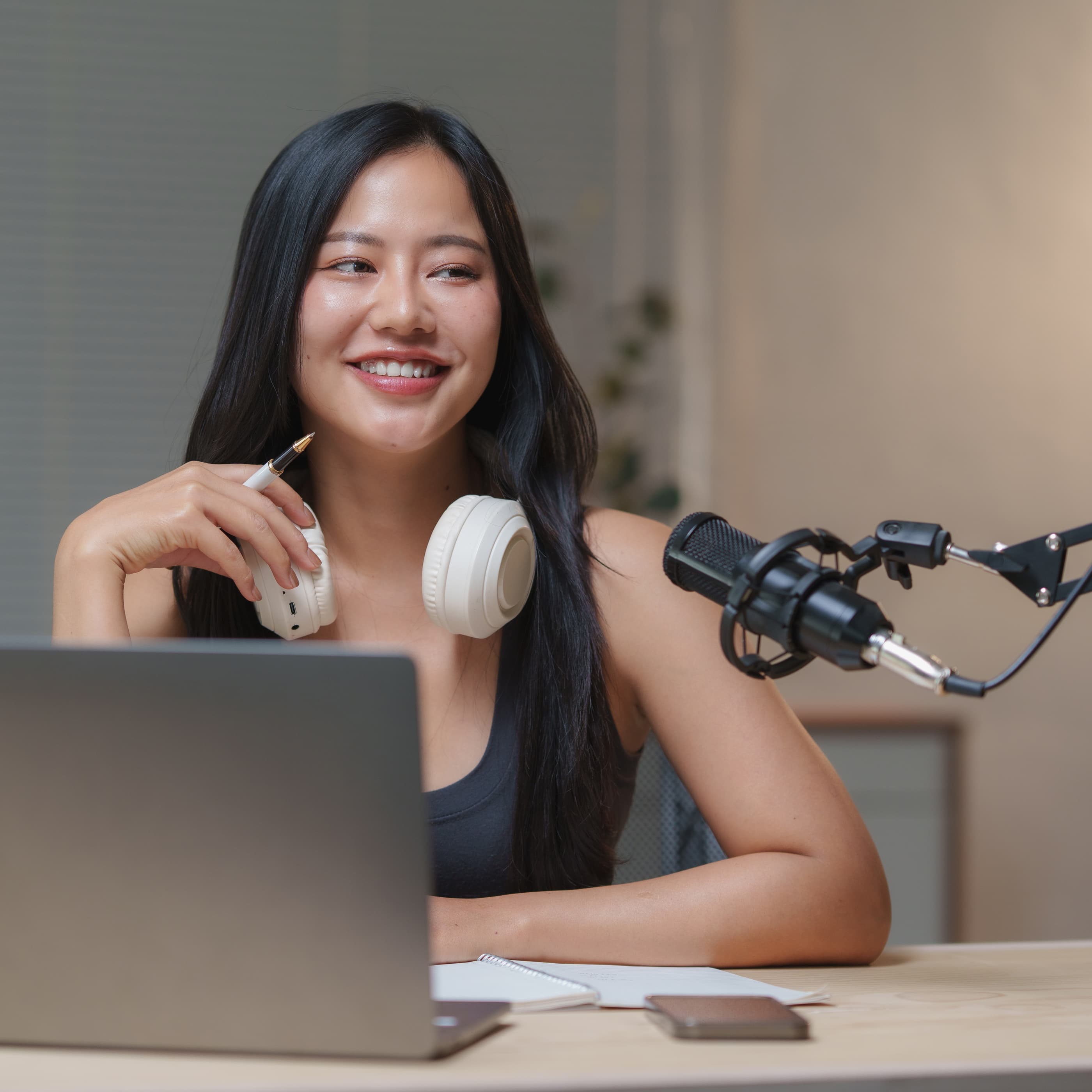 在 Ephoto Dam 照片库解决方案的专业视频工作室中,坐着的妇女对着拍摄她的摄像机微笑。